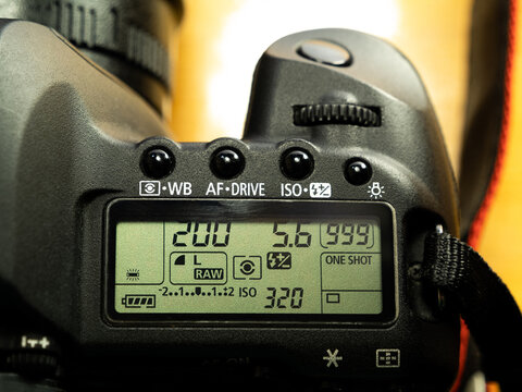 Professional Canon DSLR camera photo settings display, set up screen top view, closeup Manual shooting mode: shutter speed, aperture, ISO numbers displayed
