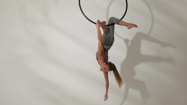 A girl of athletic build on an acrobatic ring.