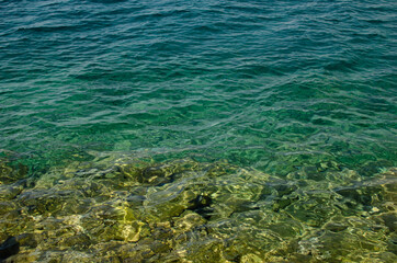Naklejka na ściany i meble The rocky background of the sea throught emerald water, Croatia.
