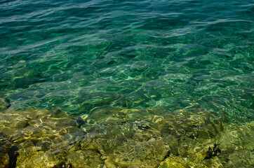 Fototapeta na wymiar The rocky background of the sea throught emerald water, Croatia