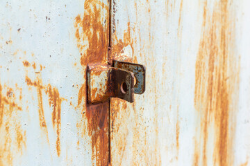 Rust.Fragment of a rusty metal door.Rusty hinges for the lock.