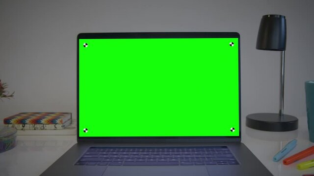 Laptop Computer Showing Green Chroma Key Screen. Colorful desk elements. Dolly in. Home office. Track points with perspective corner pin.   