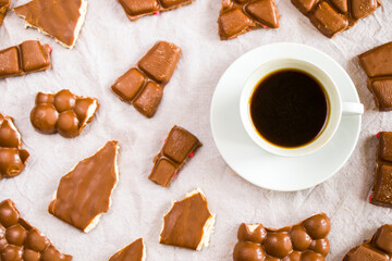 Cup of black espresso coffee and chocolate bars on the white cloth background