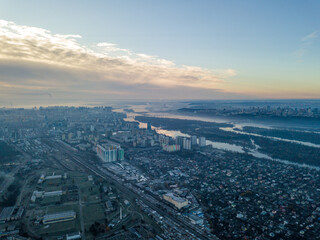 Fototapeta na wymiar Aerial high flight over Kiev, haze over the city. Autumn morning, the Dnieper River is visible on the horizon.