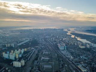 Naklejka na ściany i meble Aerial high flight over Kiev, haze over the city. Autumn morning, the Dnieper River is visible on the horizon.