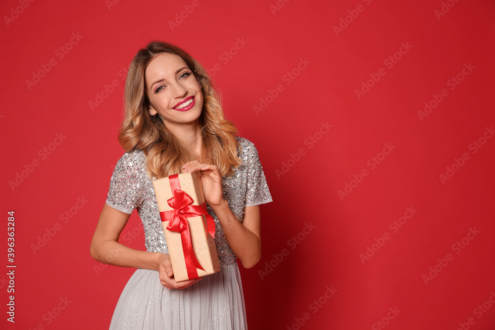 Poster Happy woman with gift box on red background, space for text. Christmas party