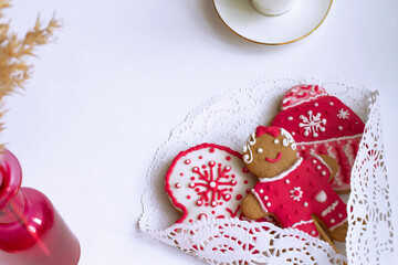Set of Christmas gingerbread on a white table. Pink figures made of ginger-honey dough. The concept of home baking, handmade. Edible Souvenirs, handmade jewelry. Top view. Copy space