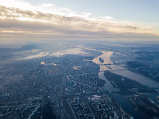 Aerial high flight over Kiev, haze over the city. Autumn morning, the Dnieper River is visible on the horizon.