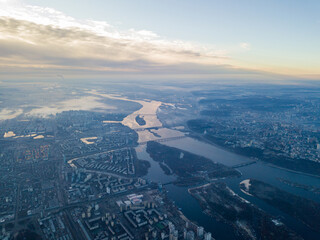 Aerial high flight over Kiev, haze over the city. Autumn morning, the Dnieper River is visible on...