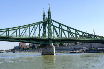 Fototapeta na wymiar Liberty Bridge (Szabadság híd) in Bu in Budapest, Hungary - The Freedom Bridge is a bridge in Budapest. It was built in 1896. It is made of steel girders. The two pillars are decorated with two statue