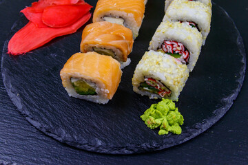 Set of sushi rolls on a black stone slate