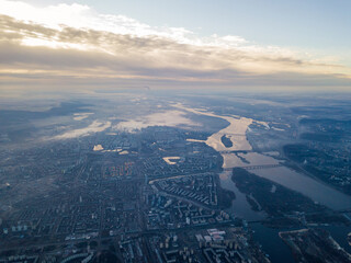 Aerial high flight over Kiev, haze over the city. Autumn morning, the Dnieper River is visible on...