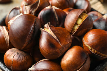 Tasty roasted edible chestnuts in frying pan, closeup