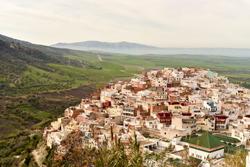 vue aérienne sur la ville de Moulay Idriss au Maroc, perchée sur une colline avec la plaine à l'horizon 