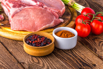 fresh raw new-york steak on wooden Board on wooden background with salt and pepper in a rustic style.