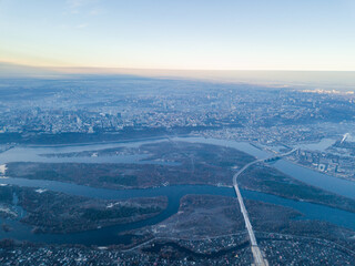 Aerial high flight over Kiev, haze over the city. Autumn morning, the Dnieper River is visible on...