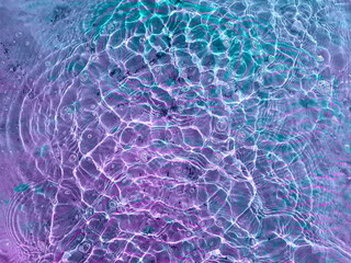 Water texture with circular streaks on the surface, bubbles and sun glare. Concept background,...