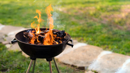 Burning wood in barbeque grill, preparing hot coals for grilling meat in the back yard. Shallow...