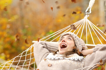 Amazed woman in autumn watching leafs falling
