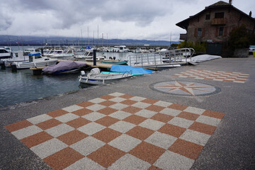 view of the harbor of the port with colorful painting on the dock by lake Geneva