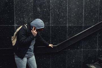 Very young hungry and scared homeless teenager girl standing alone on the street in the cold winter...