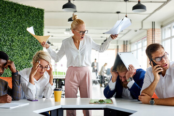 rude angry female boss executive is dissatisfied irritated by employees, scream at them, incompetent workers. in modern office - obrazy, fototapety, plakaty