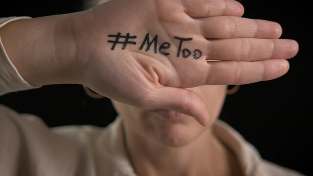 Me too abuse. A woman support the movement and show her hand with a hashtag metoo.