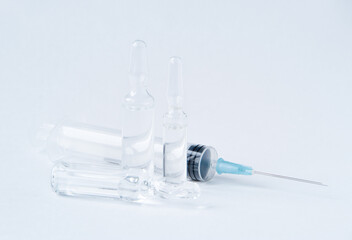 Vaccination. Syringe and medicine on a light background.