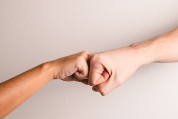 woman and man bumping fists on a white background.