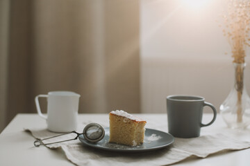 Piece of homemade cake with a cup of cappuccino on table with linen tablecloth. Morning breakfast. Top view, flat lay, copy space