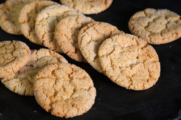 homemade honey cookies with cracks on a dark background. 