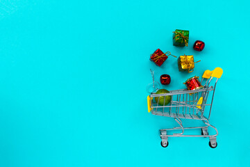 shopping grocery cart with gifts on blue background. Concept of business, shopping, black friday sales. Top view or flat lay composition