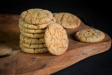 homemade honey cookies with cracks on a wooden frame and dark background. 