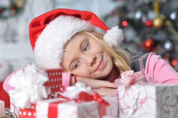 Fototapeta na wymiar Portrait of happy girl sitting with Christmas presents