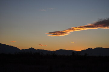 Beautiful cloud colourd by the sun behind the Mountains