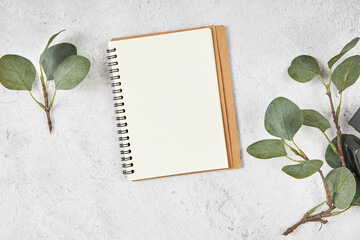 White blank note paper and big green tropical leaves on background. Flat lay. Top view. Copy space.