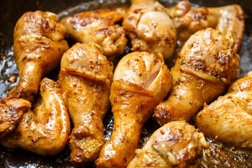 Chicken drumsticks and wings marinated with soy sauce on a baking sheet.