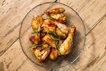 Marinated baked chicken drumsticks and wings in a plate.