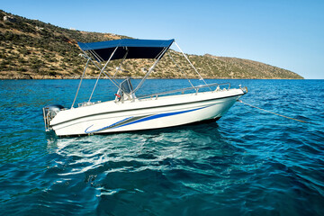 Sea landscape with the self drive motor boat for rent in white and blue color on a sea during...