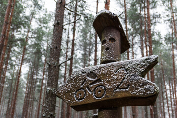 Snowy wooden signpost on a cycle path two kilometers away.