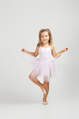 Naklejka premium little child girl dreams of becoming a ballerina. ballet dancer in pink tutu