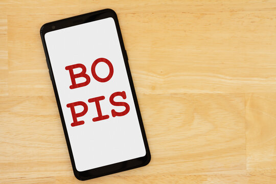BOPIS message on a cell phone on a wood desk