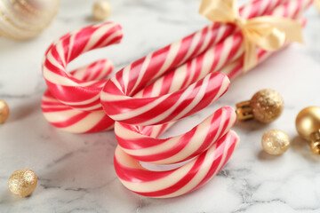 Bunch of Christmas candy canes on white marble table, closeup