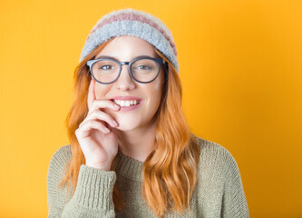 Front view face and shoulders of beautiful young woman. Close up happy young smiling trendy girl, isolated on yellow background. Lovely girl with strong white teeth