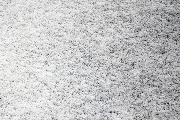 White snow covered black surface. Snow on the ground.