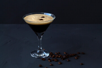Espresso Martini cocktail garnished with coffee beans on dark table. Martini glass on a black background. alcohol drinks. copy space.