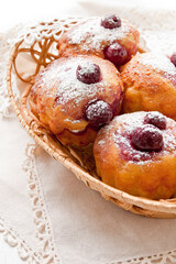 Homemade Cherry Muffins in a wicker basket on a white background