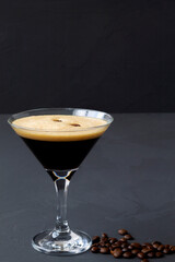 Espresso Martini cocktails garnished with coffee beans on table. Martini glass on a black...