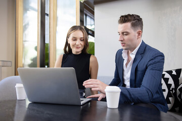 Caucasian Businessman Presents the Project to His Colleague or Customer on His Laptop