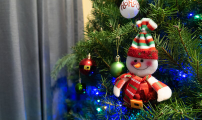 Figura de muñeco de nieve colgada en pino navideño